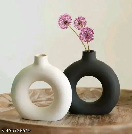 New Ring PCENFAP015 Planter (Pack of 2, 5 Inch, Black and White)Name: New Ring Planter (Pack of 2, 5 Inch, Black and White)Material: CeramicColor: BlackProduct Length: 10 cmProduct Height: 10 cmProduct Breadth: 10 cmNet Quantity (N): 2 seamlessly blends elegance with functionality. Its smooth surface, kissed by gentle curves, cradles verdant life with grace. 